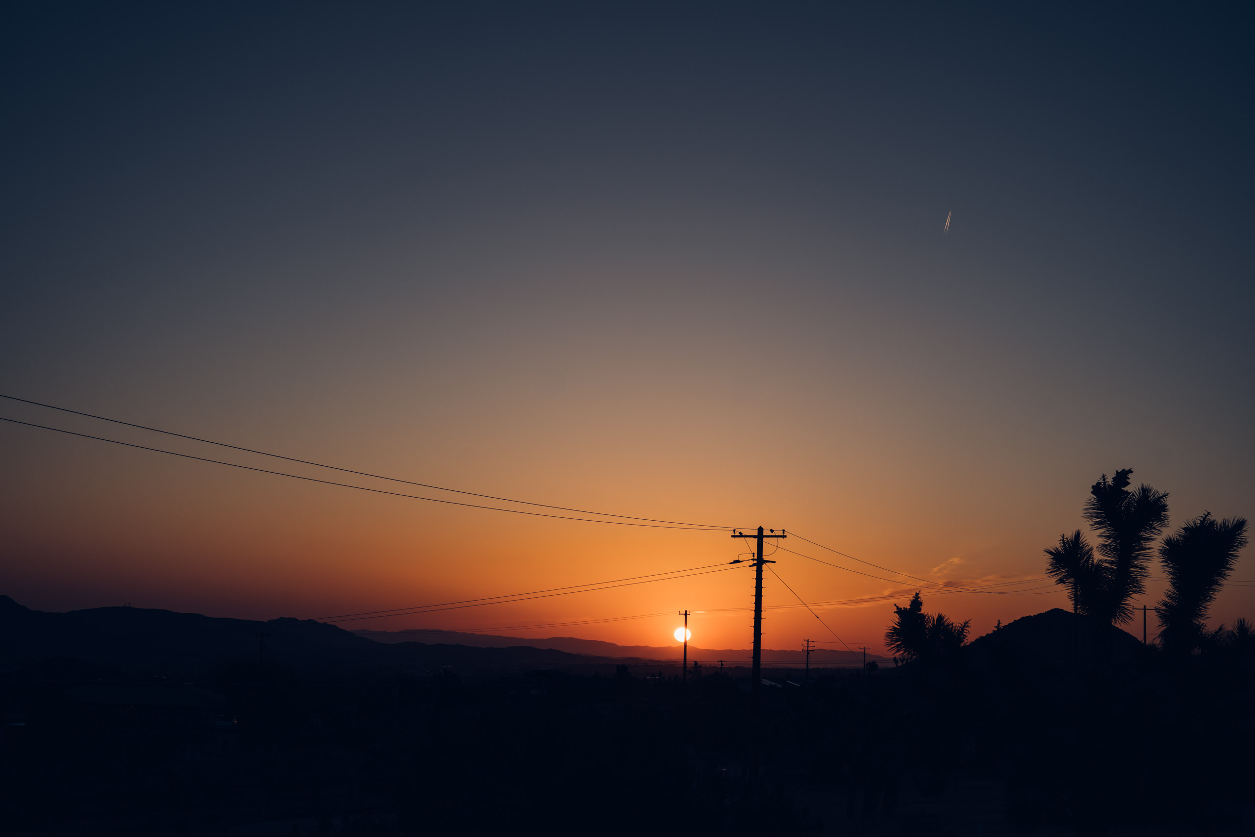 Sunrise masked by a telephone pole 
